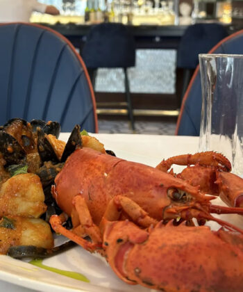 A beautifully plated lobster and mussels, showcasing fresh seafood at a fine dining restaurant. - Hausion