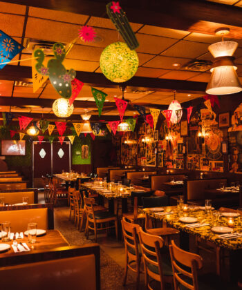 A vibrant restaurant filled with colorful decorations and inviting tables, creating a lively dining atmosphere. - Hausion