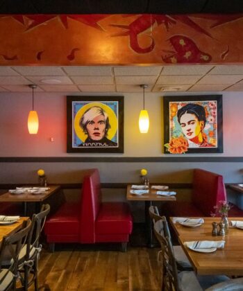 Welcoming restaurant showcasing red booths and decorative paintings, perfect for a comfortable and enjoyable dining experience. - Hausion