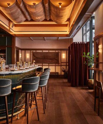 The hotel bar showcases rich wood and leather accents, offering a cozy and sophisticated setting for relaxation. - Hausion